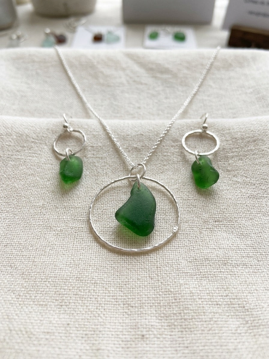 Matching necklace and earrings set featuring green sea glass and hammered circles
