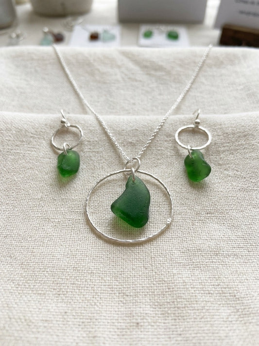 Matching necklace and earrings set featuring green sea glass and hammered circles